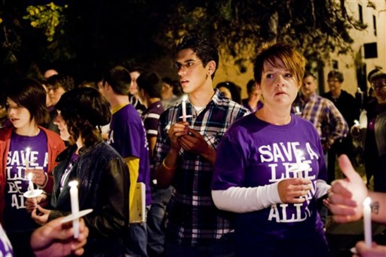 Fares Akremi, 17, center, waits before the start of a candlelight procession down Ninth Street to commemorate the recent deaths of gay teens,  Wednesday at The Center Project in Columbia, Mo. 